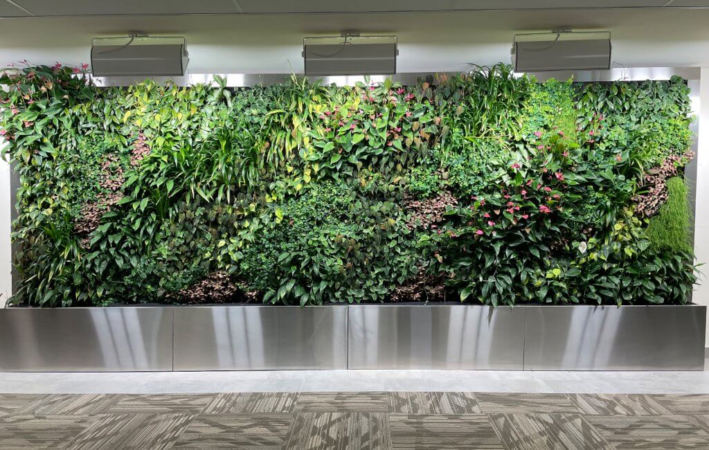 Wall of live plants with pink and red flowers